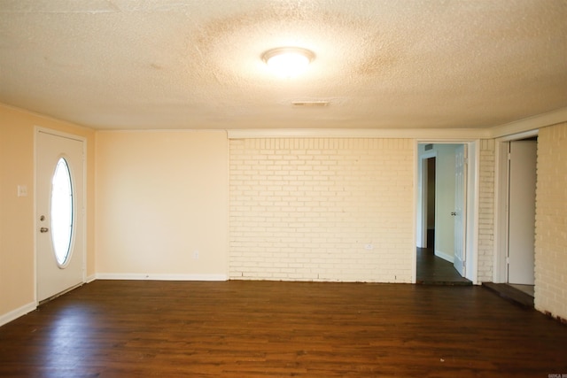 6914 Juniper Rd, Little Rock, AR 72209 - entryway with a textured ceiling, dark wood finished floors, brick wall, and baseboards