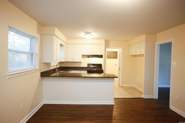 6914 Juniper Rd, Little Rock, AR 72209 - kitchen with stove, a peninsula, a sink, and dark countertops