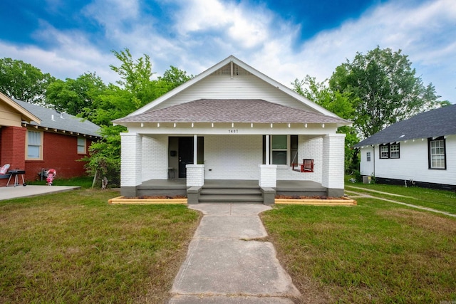 1407 Hanger St, Little Rock, AR 72202 - view of front of house with covered porch, brick siding, roof with shingles, and a front lawn