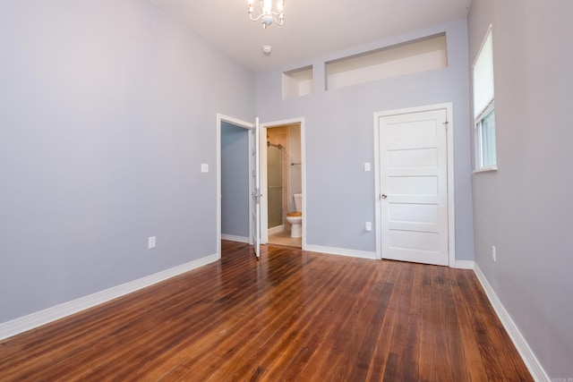 1407 Hanger St, Little Rock, AR 72202 - unfurnished bedroom with wood finished floors, a chandelier, baseboards, and connected bathroom