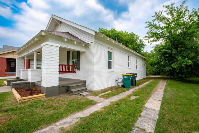 1407 Hanger St, Little Rock, AR 72202 - view of property exterior with brick siding, a porch, and a yard