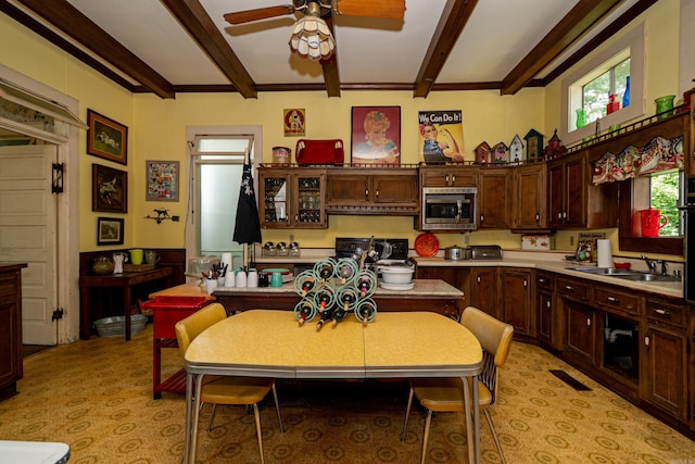 344 S Main St, Monticello, AR 71655 - kitchen with stainless steel microwave, a ceiling fan, range, beam ceiling, and light countertops