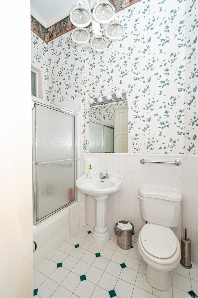 344 S Main St, Monticello, AR 71655 - bathroom with wallpapered walls, toilet, bath / shower combo with glass door, wainscoting, and tile patterned flooring