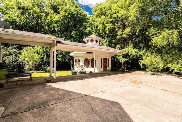 344 S Main St, Monticello, AR 71655 - view of patio featuring an outbuilding, concrete driveway, view of scattered trees, and a carport