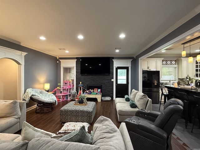 3117 Stonehenge Dr, Searcy, AR 72143 - living room featuring ornamental molding, arched walkways, wood finished floors, recessed lighting, and a fireplace