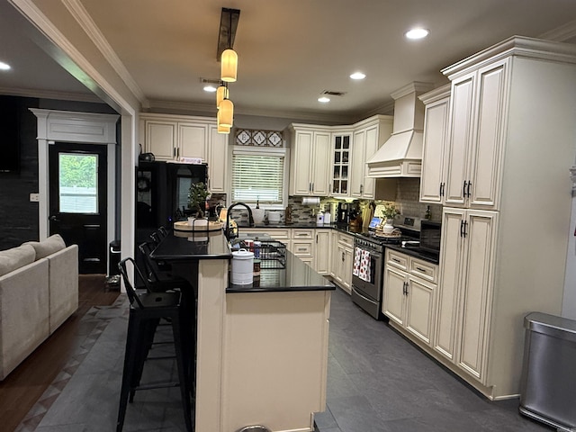 3117 Stonehenge Dr, Searcy, AR 72143 - kitchen with stainless steel gas range, dark countertops, healthy amount of natural light, premium range hood, and crown molding
