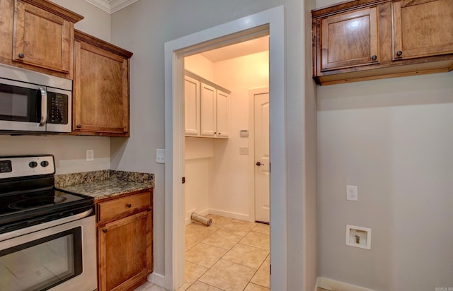 106 Venezia Ln, Maumelle, AR 72113 - kitchen featuring stainless steel appliances, light stone counters, ornamental molding, light tile patterned floors, and baseboards