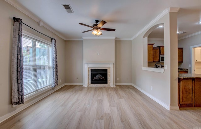 106 Venezia Ln, Maumelle, AR 72113 - unfurnished living room with light wood-type flooring, a ceiling fan, crown molding, a tiled fireplace, and baseboards