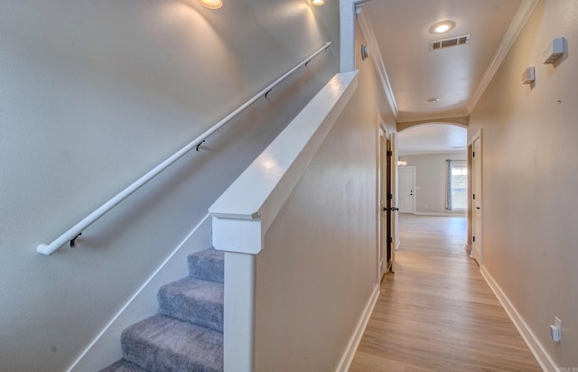 106 Venezia Ln, Maumelle, AR 72113 - stairway featuring crown molding, arched walkways, wood finished floors, and baseboards