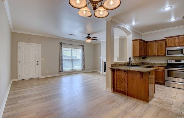 106 Venezia Ln, Maumelle, AR 72113 - kitchen featuring appliances with stainless steel finishes, brown cabinets, a fireplace, a peninsula, and a sink