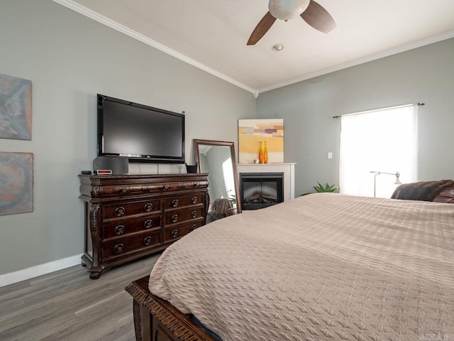 14 Woodridge Dr, Little Rock, AR 72204 - bedroom with wood finished floors, baseboards, ornamental molding, a glass covered fireplace, and a ceiling fan