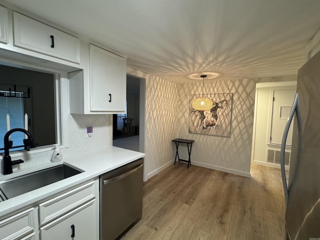 7306 Dakota Dr, North Little Rock, AR 72116 - kitchen featuring appliances with stainless steel finishes, a sink, white cabinetry, light countertops, and light wood-style floors