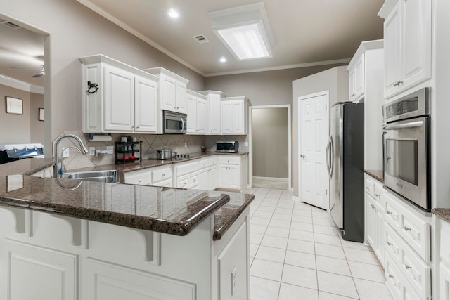 223 Maranes Cir, Maumelle, AR 72113 - kitchen with stainless steel appliances, a sink, a peninsula, backsplash, and crown molding