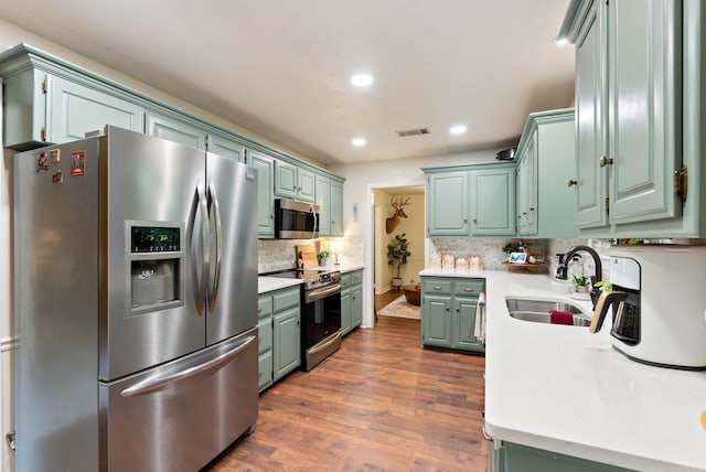 5623 Ridgeway Dr, Benton, AR 72019 - kitchen featuring stainless steel appliances, a sink, light countertops, backsplash, and dark wood-style floors