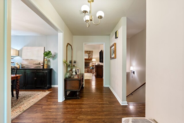5623 Ridgeway Dr, Benton, AR 72019 - hallway featuring dark wood-type flooring, baseboards, and a chandelier