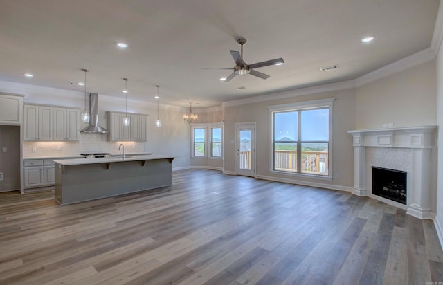121 Majestic Cir, Maumelle, AR 72113 - unfurnished living room featuring a ceiling fan, a fireplace, crown molding, light wood-type flooring, and a sink