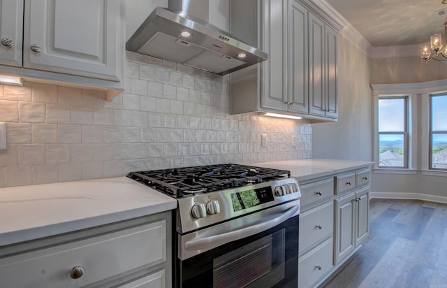 121 Majestic Cir, Maumelle, AR 72113 - kitchen featuring gas range, extractor fan, light wood-style floors, a chandelier, and baseboards