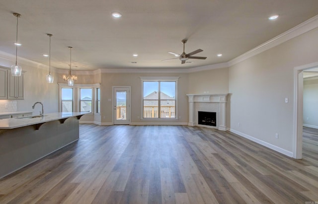 121 Majestic Cir, Maumelle, AR 72113 - unfurnished living room featuring a sink, ceiling fan, recessed lighting, wood finished floors, and crown molding