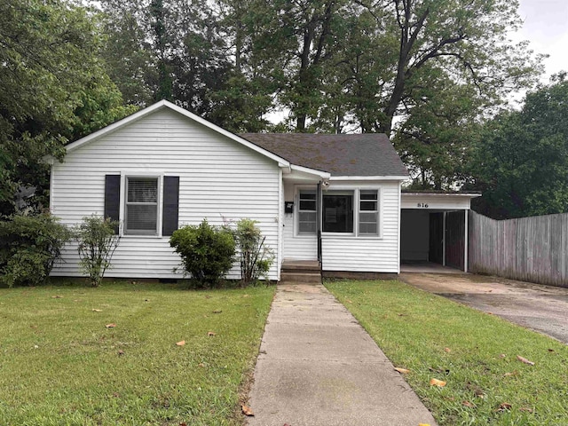 view of front of home with concrete driveway, a carport, and a shingled roof