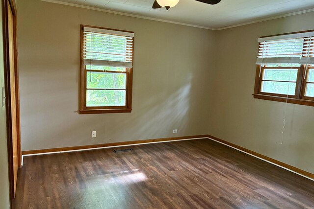 unfurnished room featuring dark wood-type flooring, ornamental molding, baseboards, and ceiling fan