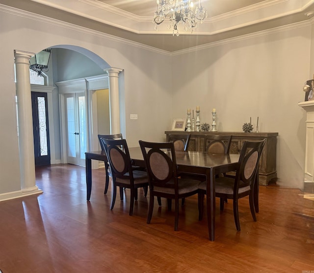 dining space featuring a chandelier, ornate columns, arched walkways, and crown molding