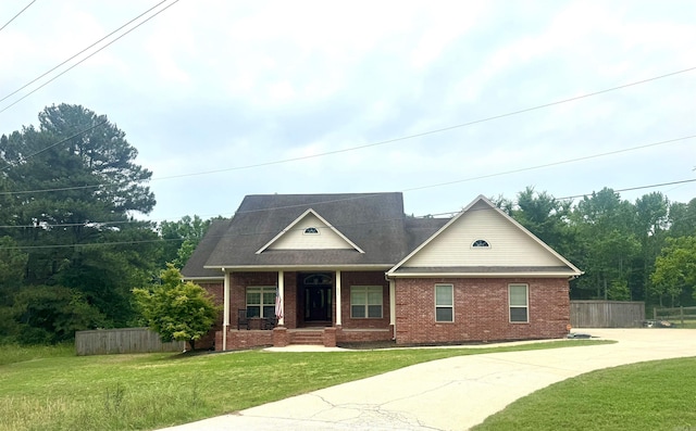 view of front facade with brick siding, a porch, and driveway