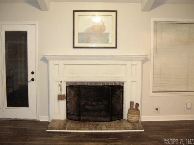 11 Sharondale Ct, Maumelle, AR 72113 - detailed view of a fireplace with raised hearth, wood finished floors, and baseboards