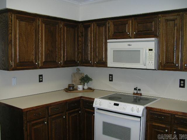 11 Sharondale Ct, Maumelle, AR 72113 - kitchen featuring white appliances, light countertops, and dark brown cabinetry
