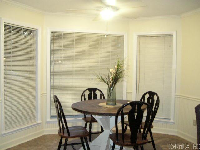 11 Sharondale Ct, Maumelle, AR 72113 - dining space with a ceiling fan, ornamental molding, baseboards, and wainscoting