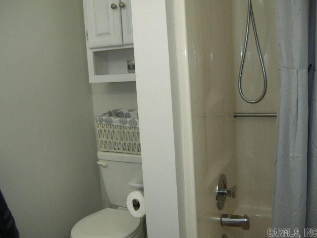 11 Sharondale Ct, Maumelle, AR 72113 - bathroom featuring shower / bathtub combination with curtain and toilet