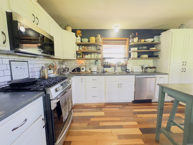 482 Ash Trl, Melbourne, AR 72556 - kitchen with stainless steel appliances, open shelves, dark countertops, a sink, and light wood-style flooring
