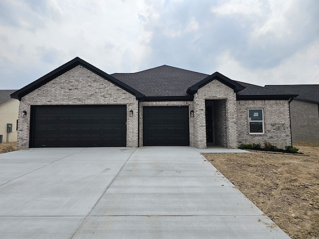 252 Kelton St, Hensley, AR 72065 - french country home featuring brick siding, a garage, driveway, and a shingled roof