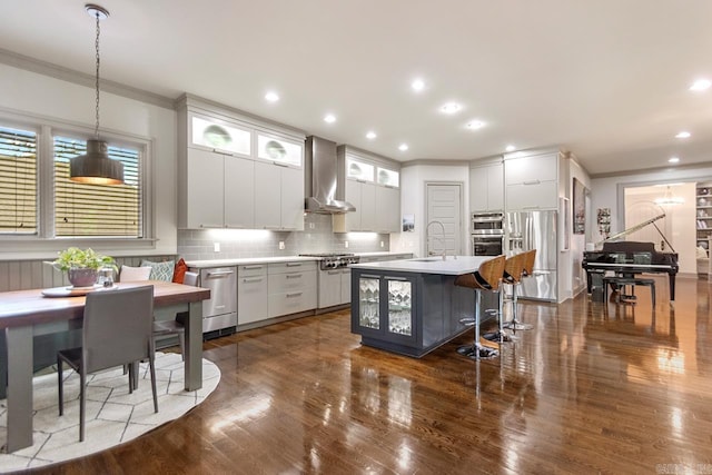145 Cove Creek Ct, Little Rock, AR 72211 - kitchen with stainless steel appliances, wall chimney range hood, ornamental molding, dark wood-style floors, and light countertops