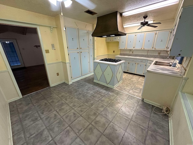 809 Emerald Gardens Dr, North Little Rock, AR 72118 - kitchen featuring a ceiling fan, island range hood, white gas stovetop, a kitchen island, and a textured ceiling