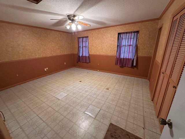 809 Emerald Gardens Dr, North Little Rock, AR 72118 - unfurnished bedroom with crown molding, wainscoting, a textured ceiling, light floors, and a closet