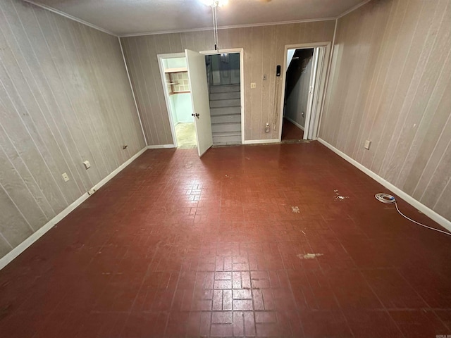 809 Emerald Gardens Dr, North Little Rock, AR 72118 - unfurnished room featuring brick patterned floors, wooden walls, baseboards, stairs, and ornamental molding