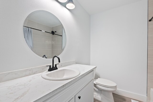 312 Eubanks Rd, Jacksonville, AR 72076 - bathroom with toilet, vanity, a tile shower, and wood finished floors