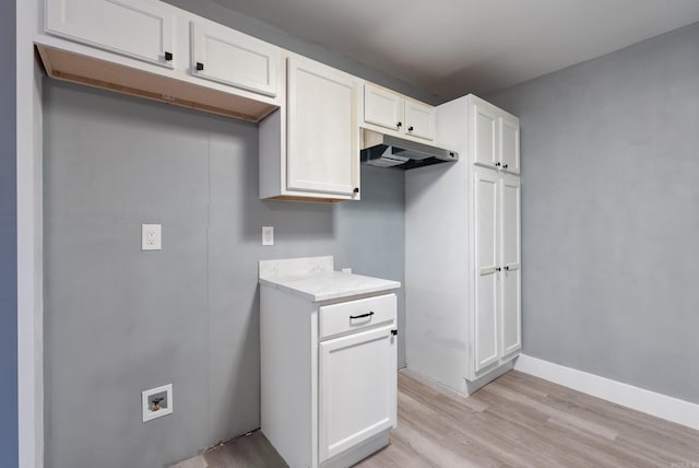 312 Eubanks Rd, Jacksonville, AR 72076 - kitchen with light wood-type flooring, under cabinet range hood, white cabinetry, and light stone counters