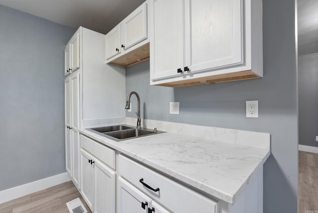 312 Eubanks Rd, Jacksonville, AR 72076 - kitchen with a sink, light wood-style floors, baseboards, and white cabinets