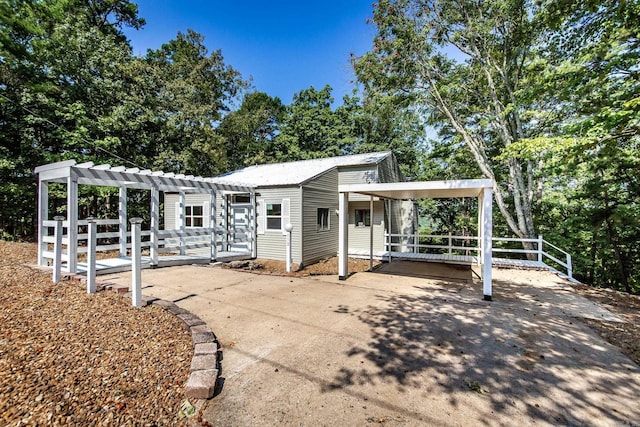 112 Ridgeview Dr, Fairfield Bay, AR 72088 - view of patio featuring a pergola, a carport, and view of scattered trees