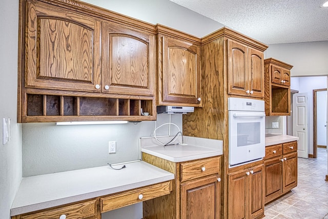 16 Zutano Ln, Hot Springs Village, AR 71909 - kitchen with white oven, open shelves, light countertops, and a textured ceiling