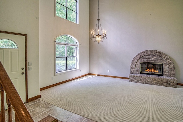 16 Zutano Ln, Hot Springs Village, AR 71909 - entryway featuring carpet floors, a chandelier, baseboards, a fireplace, and a towering ceiling