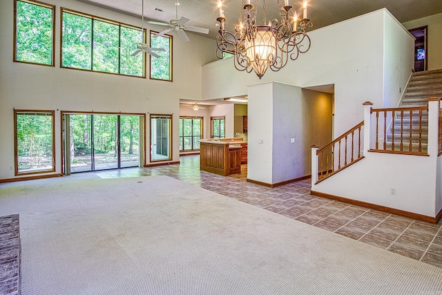 16 Zutano Ln, Hot Springs Village, AR 71909 - unfurnished living room with ceiling fan, a high ceiling, baseboards, stairway, and a chandelier