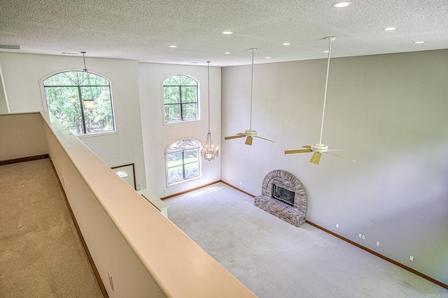 16 Zutano Ln, Hot Springs Village, AR 71909 - unfurnished living room featuring carpet flooring, baseboards, a textured ceiling, a fireplace, and recessed lighting