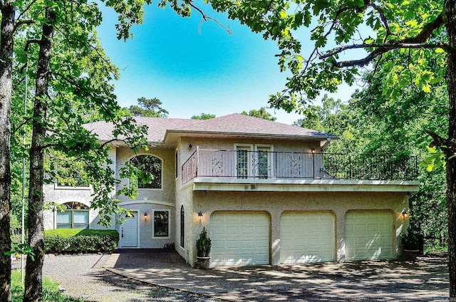 16 Zutano Ln, Hot Springs Village, AR 71909 - view of front of property with a balcony, stucco siding, driveway, and a garage