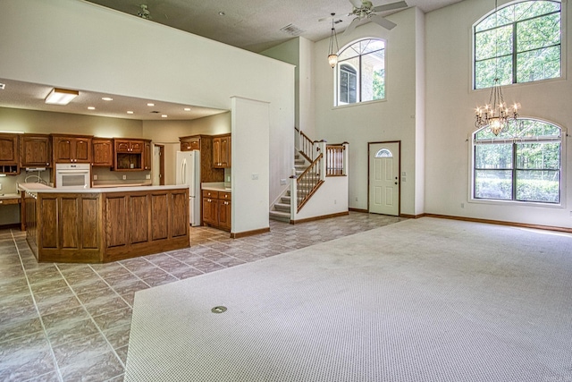16 Zutano Ln, Hot Springs Village, AR 71909 - kitchen featuring white appliances, a chandelier, light countertops, a towering ceiling, and a ceiling fan