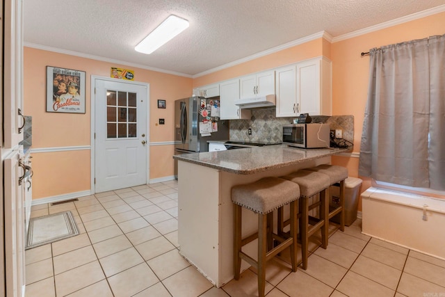 23 S Summit Dr, Cabot, AR 72023 - kitchen with appliances with stainless steel finishes, white cabinets, backsplash, light tile patterned flooring, and a peninsula
