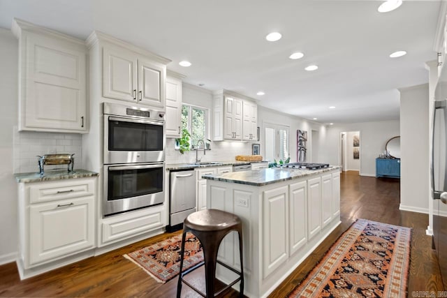 2820 N Rodney Parham Rd, Little Rock, AR 72212 - kitchen featuring stainless steel appliances, a kitchen island, decorative backsplash, dark wood-style floors, and recessed lighting
