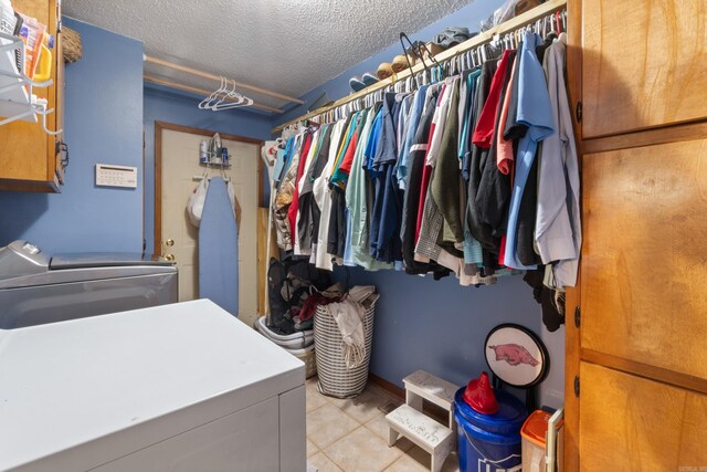 7104 Foxrun E End Dr, Mabelvale, AR 72103 - washroom with washing machine and dryer, cabinet space, and a textured ceiling
