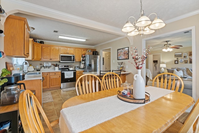dining space with a chandelier, a textured ceiling, ceiling fan, and ornamental molding